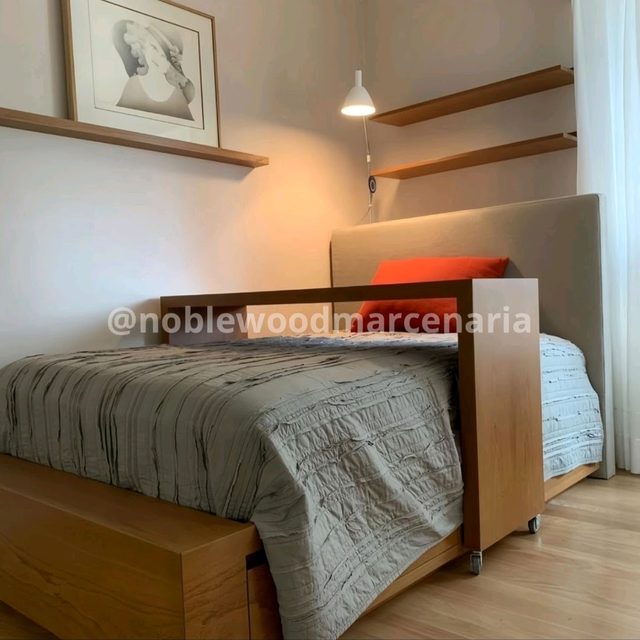 Cama em madeira com cabeceira estofada e prateleiras na parede